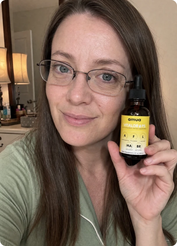 Customer in a home gym holding a VitalDrops bottle