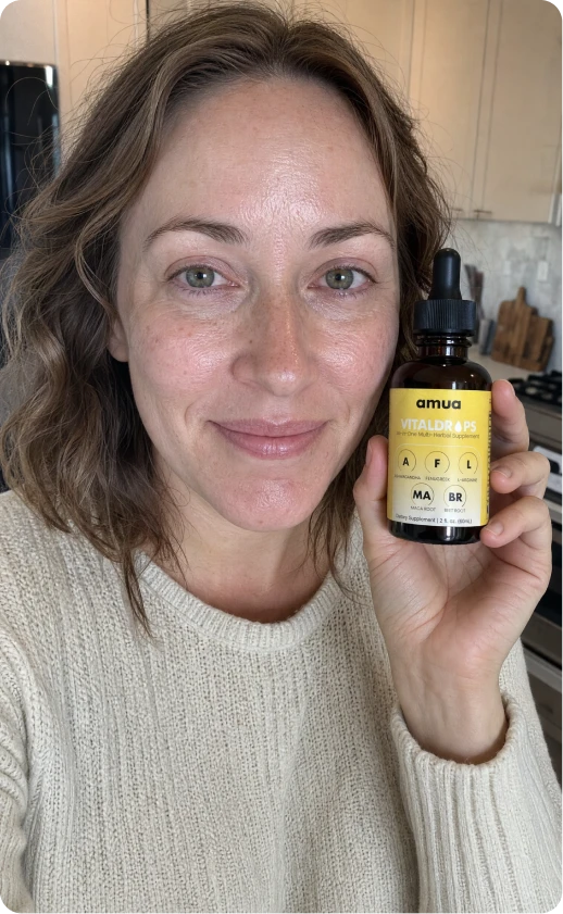 Customer with long braids smiling and holding a VitalDrops bottle