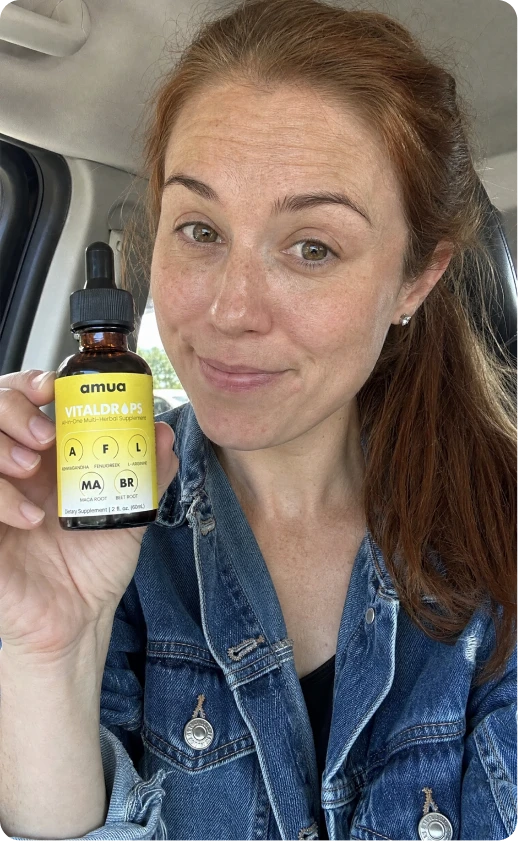 Customer with glasses and a yellow top holding a VitalDrops bottle