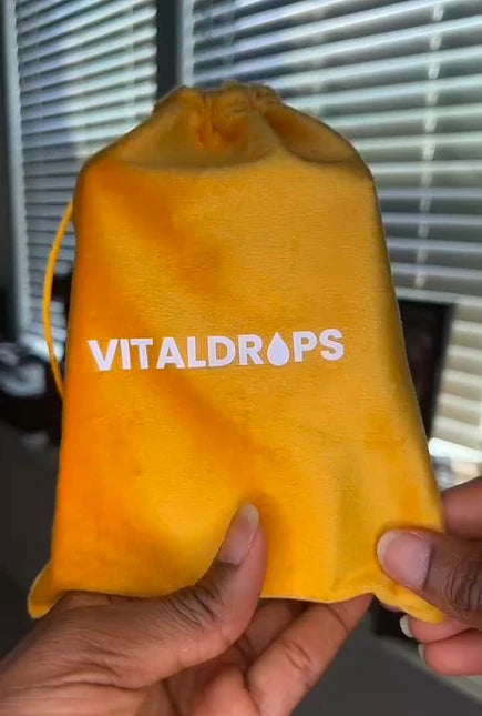 Hand holding a yellow VitalDrops pouch