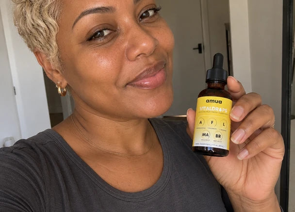 Customer with short blonde hair smiling with a VitalDrops bottle