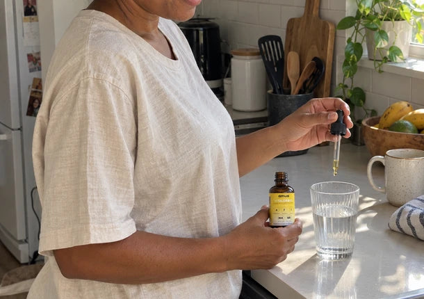 Customer in her kitchen adding VitalDrops to a glass of water
